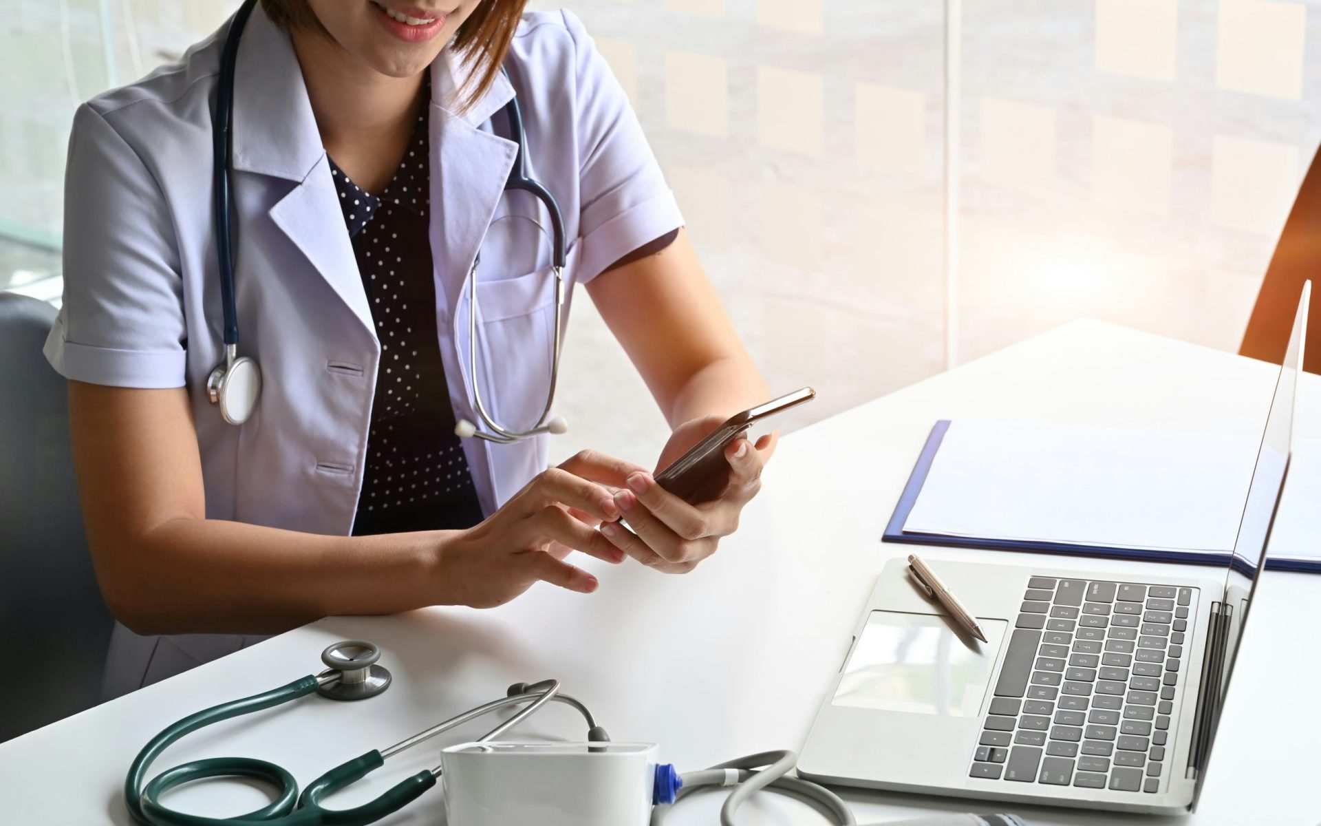 Frau guckt auf Ihr Handy. Barrierearme Praxis-Website für Arztpraxis im Mietmodell auf Smartphone dargestellt